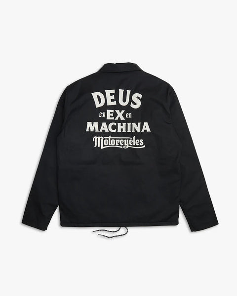 Wasserabweisendes Coach-Jacket von Deus in Schwarz mit silbernen Knöpfen. Auf der Rückseite ist eine große Stickerei in weiß "Deus ex Machina Motorcycles" angebracht.