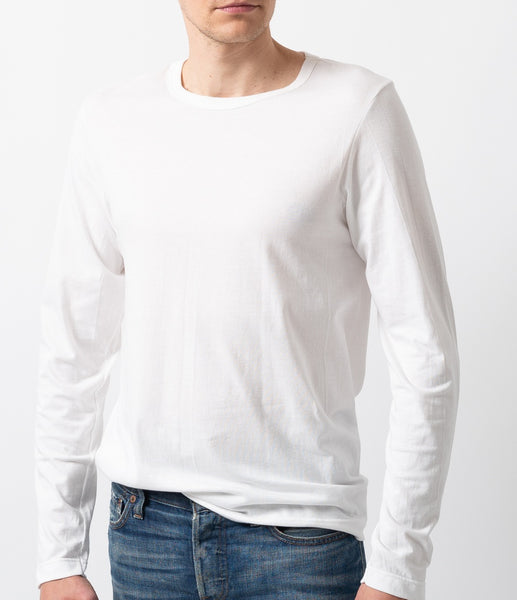 Merz b. Schwanen 1950s Longsleeve in weiß. Ein männliches Model trägt das Shirt in Kombination mit einer verwaschenen Jeans.